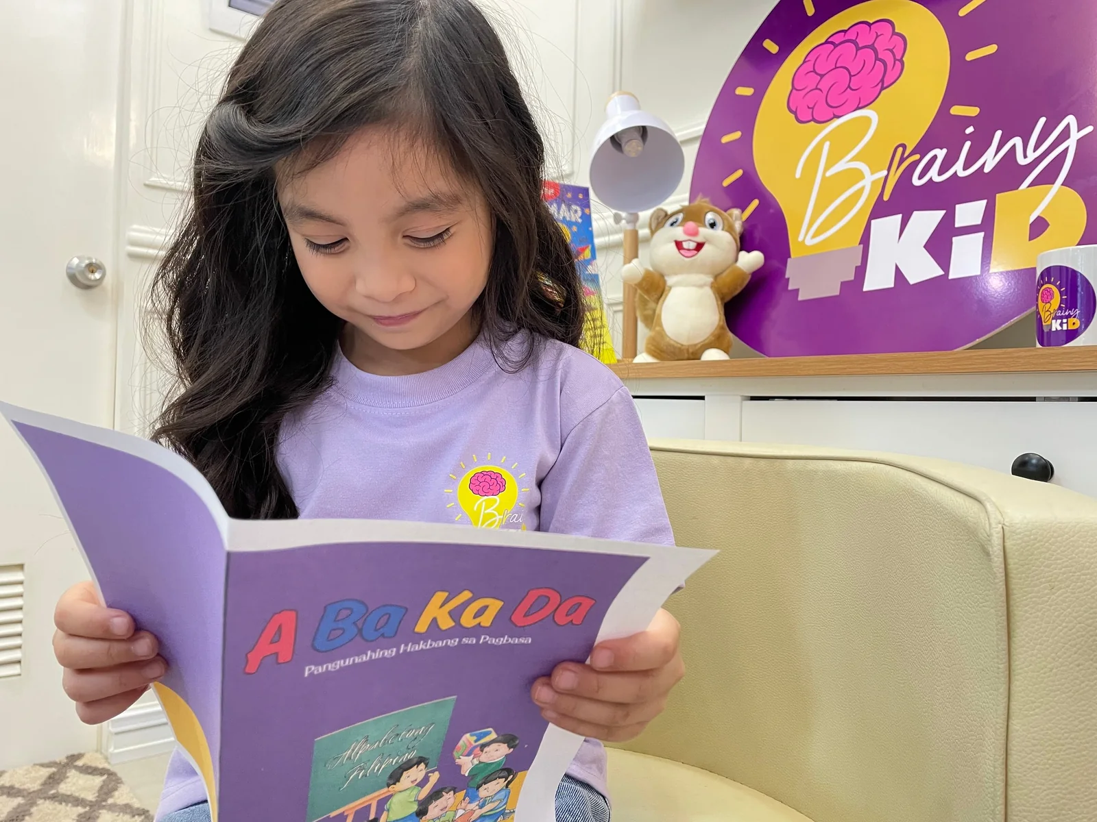 A learner exploring a reading book at Brainy Kid